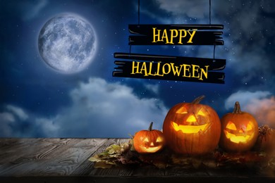 Image of Happy Halloween. Spooky pumpkin jack o'lanterns on wooden table under full moon
