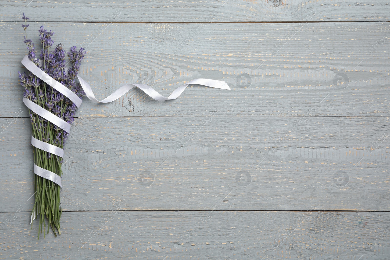 Photo of Beautiful lavender flowers with ribbon on light grey background, top view. Space for text