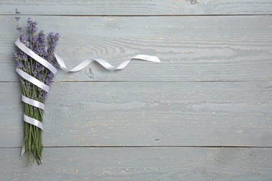 Photo of Beautiful lavender flowers with ribbon on light grey background, top view. Space for text