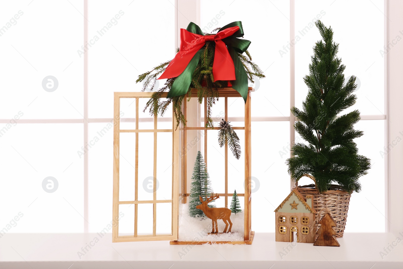 Photo of Vintage wooden lantern with beautiful Christmas decor on window sill indoors