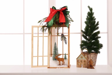 Photo of Vintage wooden lantern with beautiful Christmas decor on window sill indoors