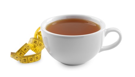 Photo of Ceramic cup of diet herbal tea and measuring tape on white background. Weight loss