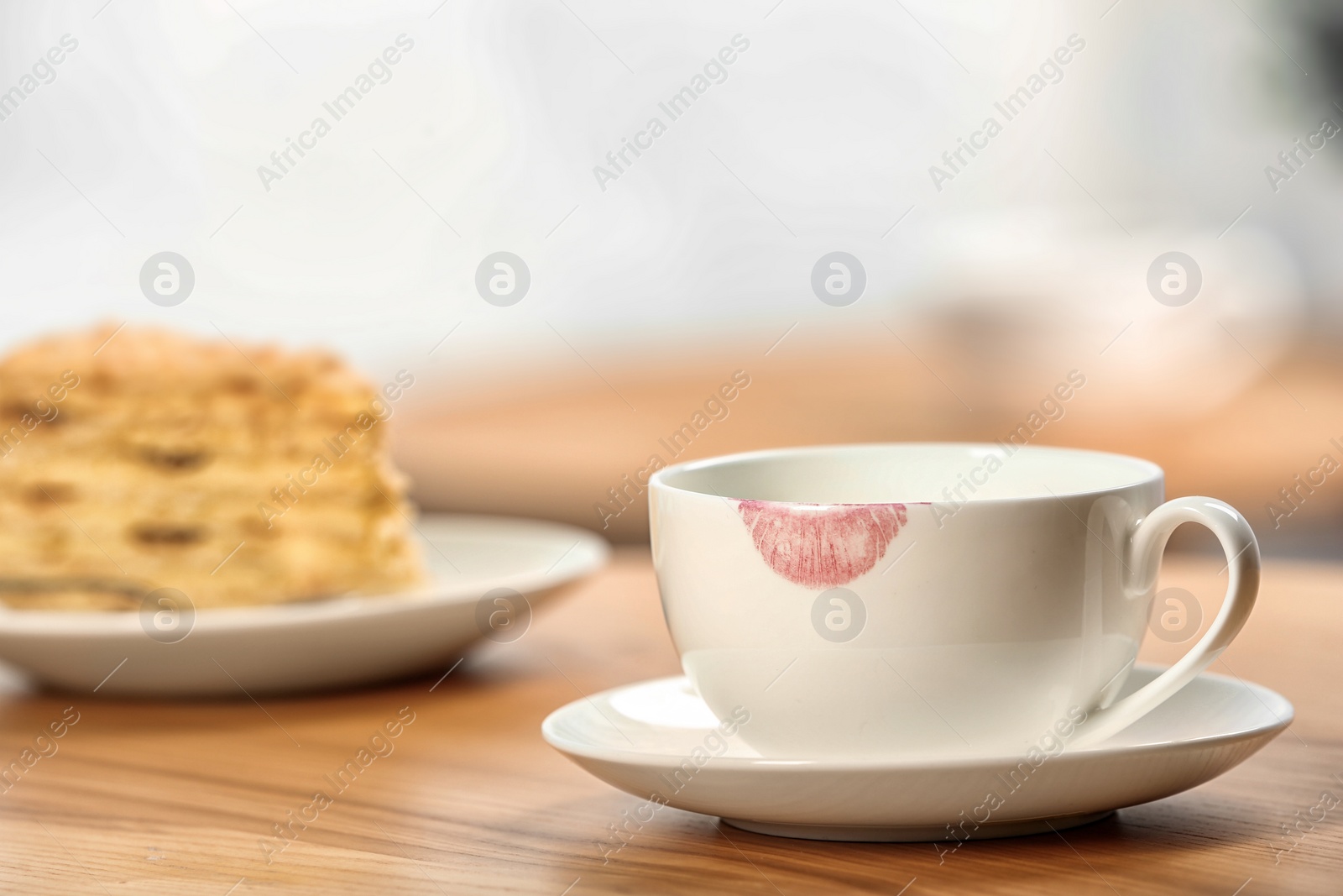 Photo of Ceramic cup with lipstick mark on table indoors. Space for text