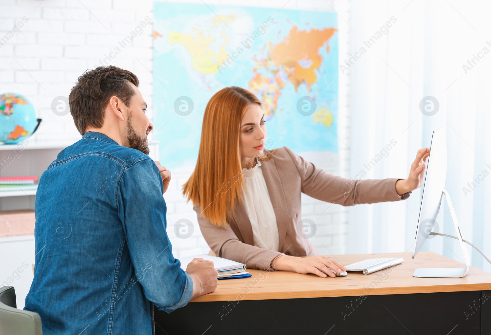 Photo of Female manager consulting client in travel agency