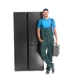 Photo of Male technician with tool box near refrigerator on white background