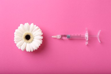 Cosmetology. Medical syringe and gerbera flower on pink background, flat lay