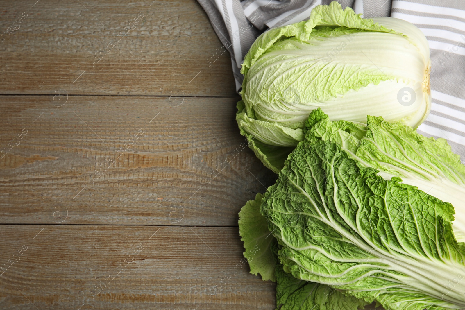 Photo of Fresh ripe Chinese cabbages on wooden table, flat lay. Space for text