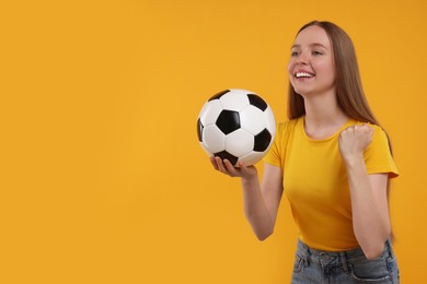 Photo of Happy sports fan with ball on yellow background. Space for text