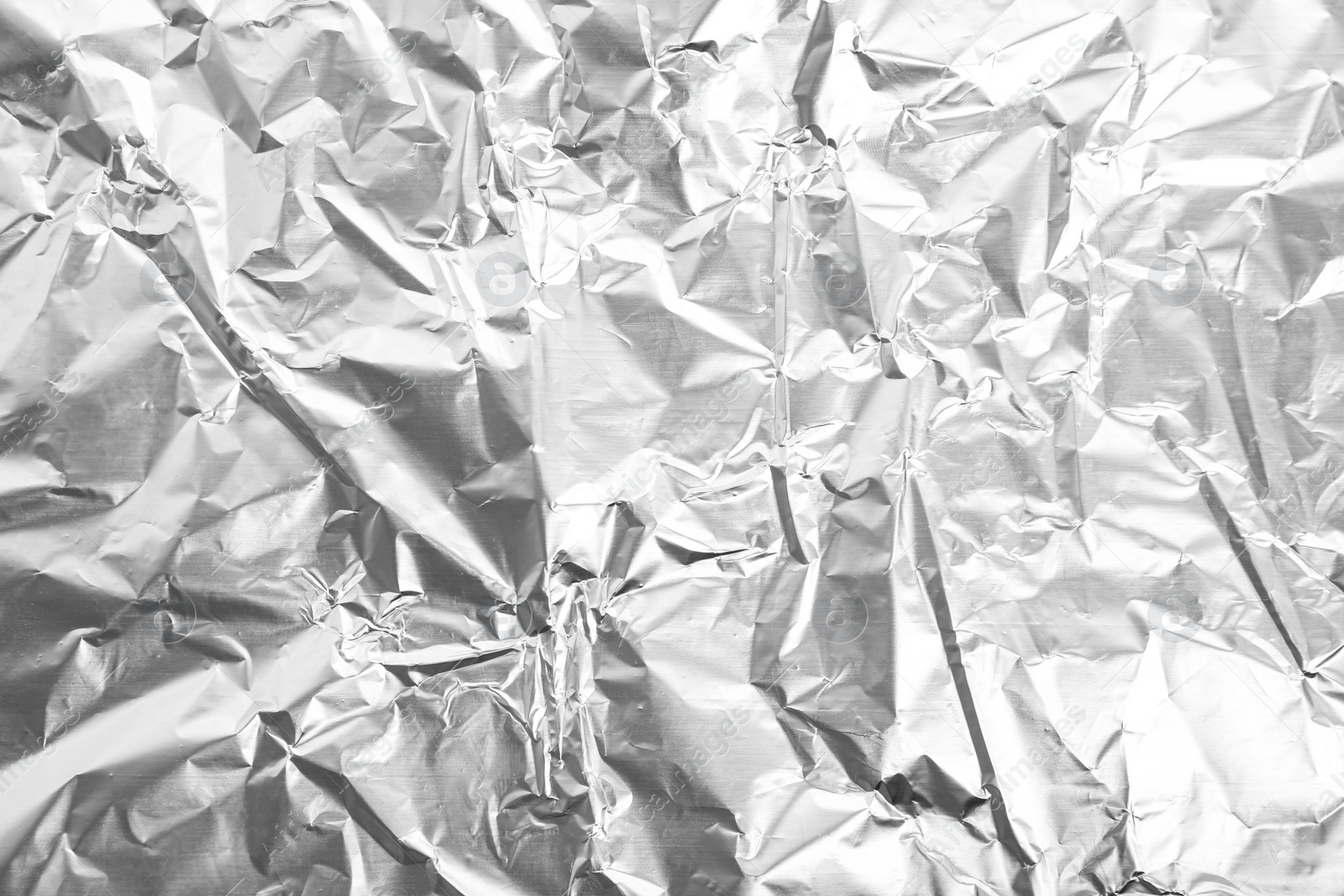 Photo of Crumpled silver foil as background, closeup view