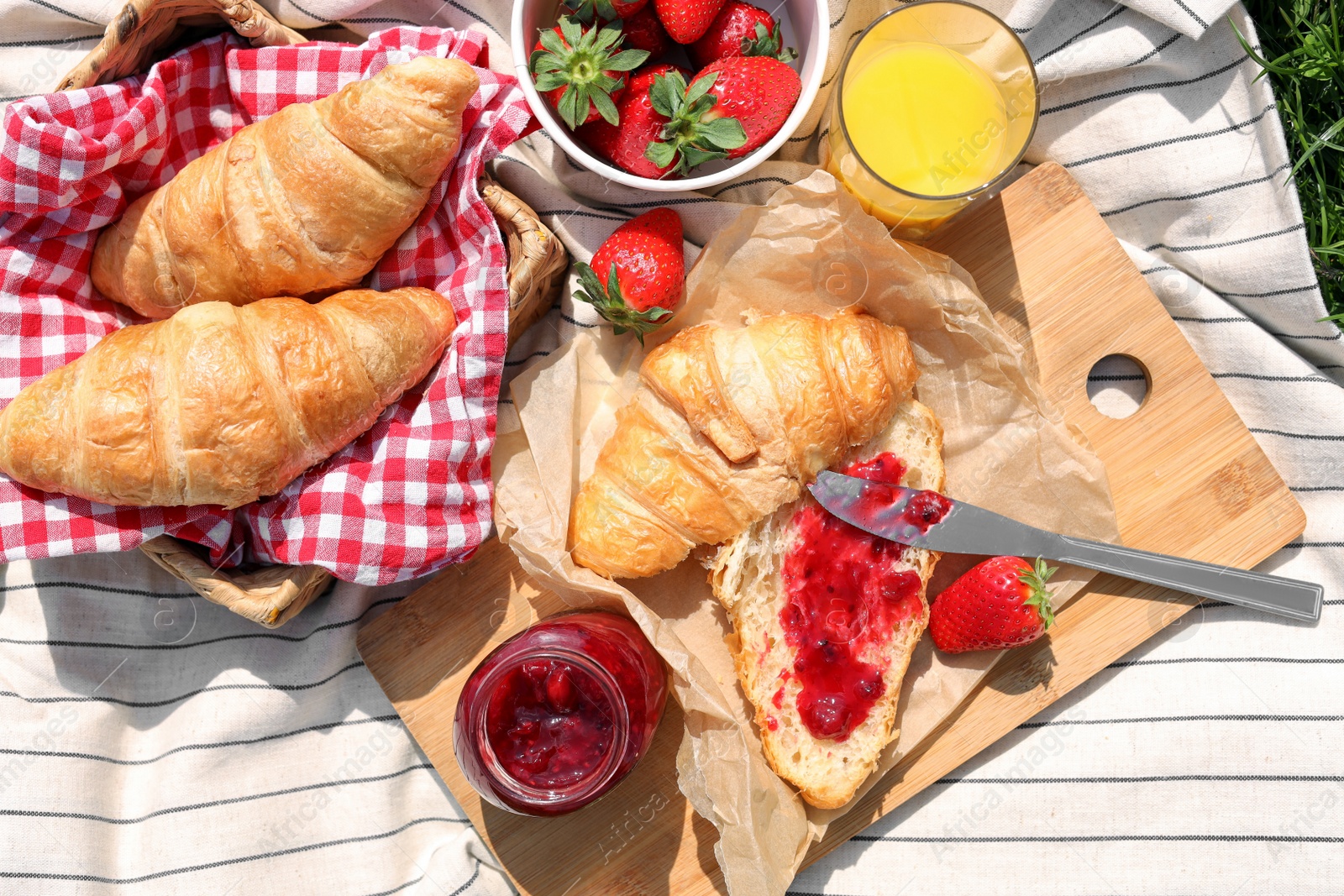 Photo of Blanket with different products outdoors, top view. Summer picnic