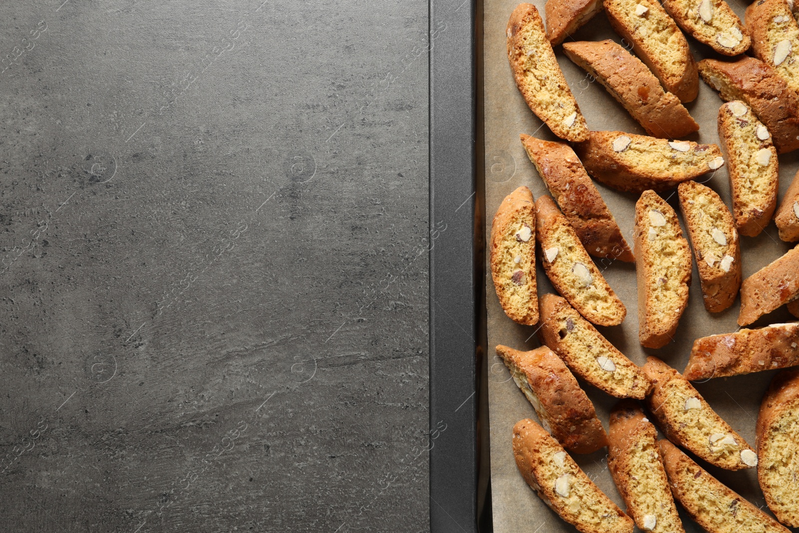 Photo of Traditional Italian almond biscuits (Cantucci) on grey table, top view. Space for text