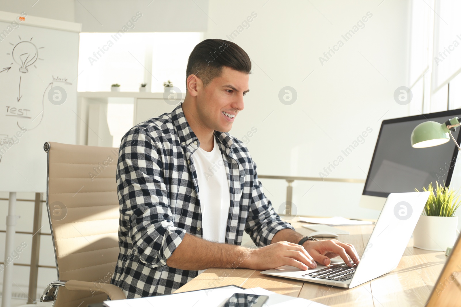 Photo of Freelancer working on laptop at table indoors