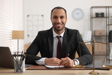 Photo of Portrait of smiling lawyer at table in office