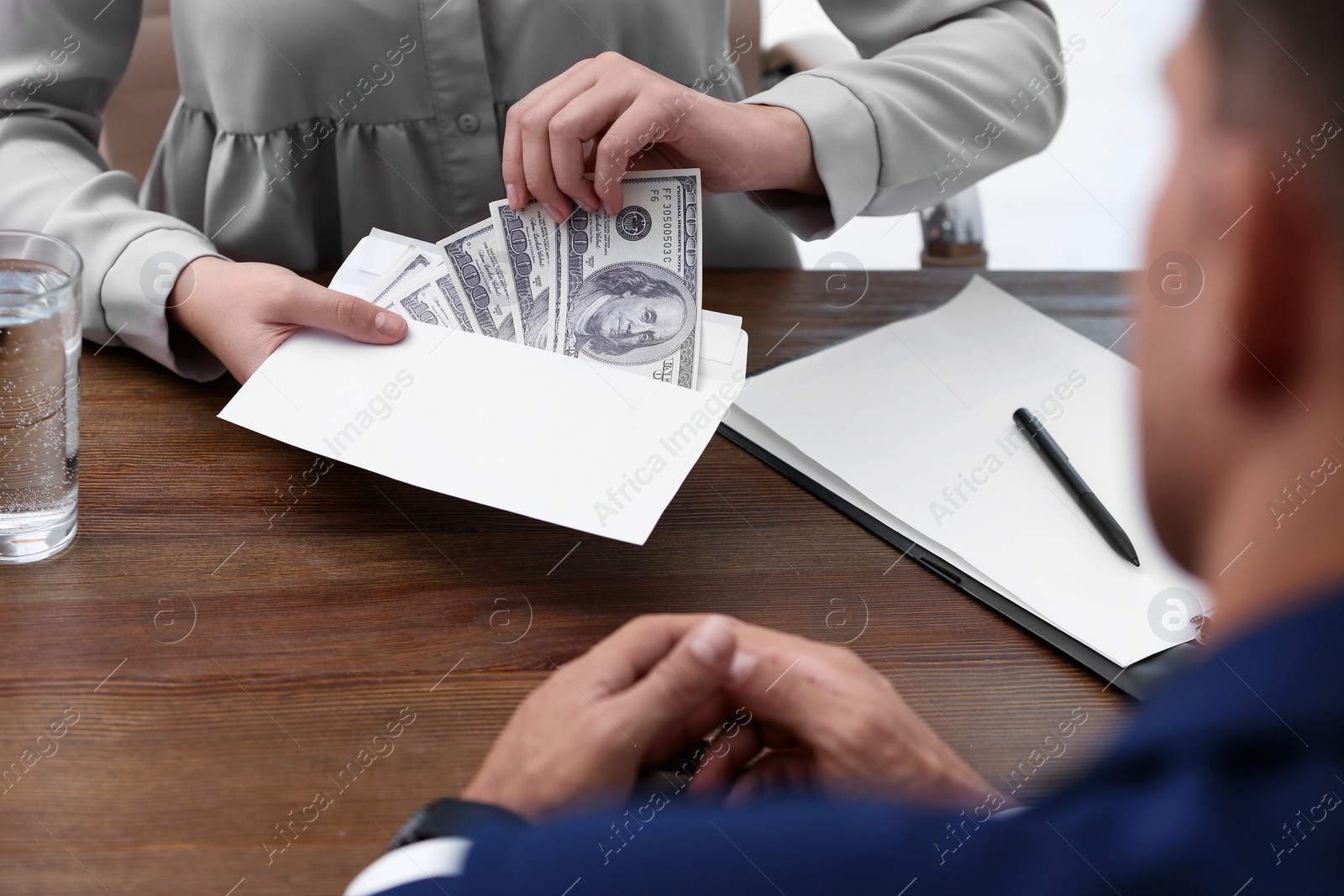 Photo of Woman with bribe money at table, closeup