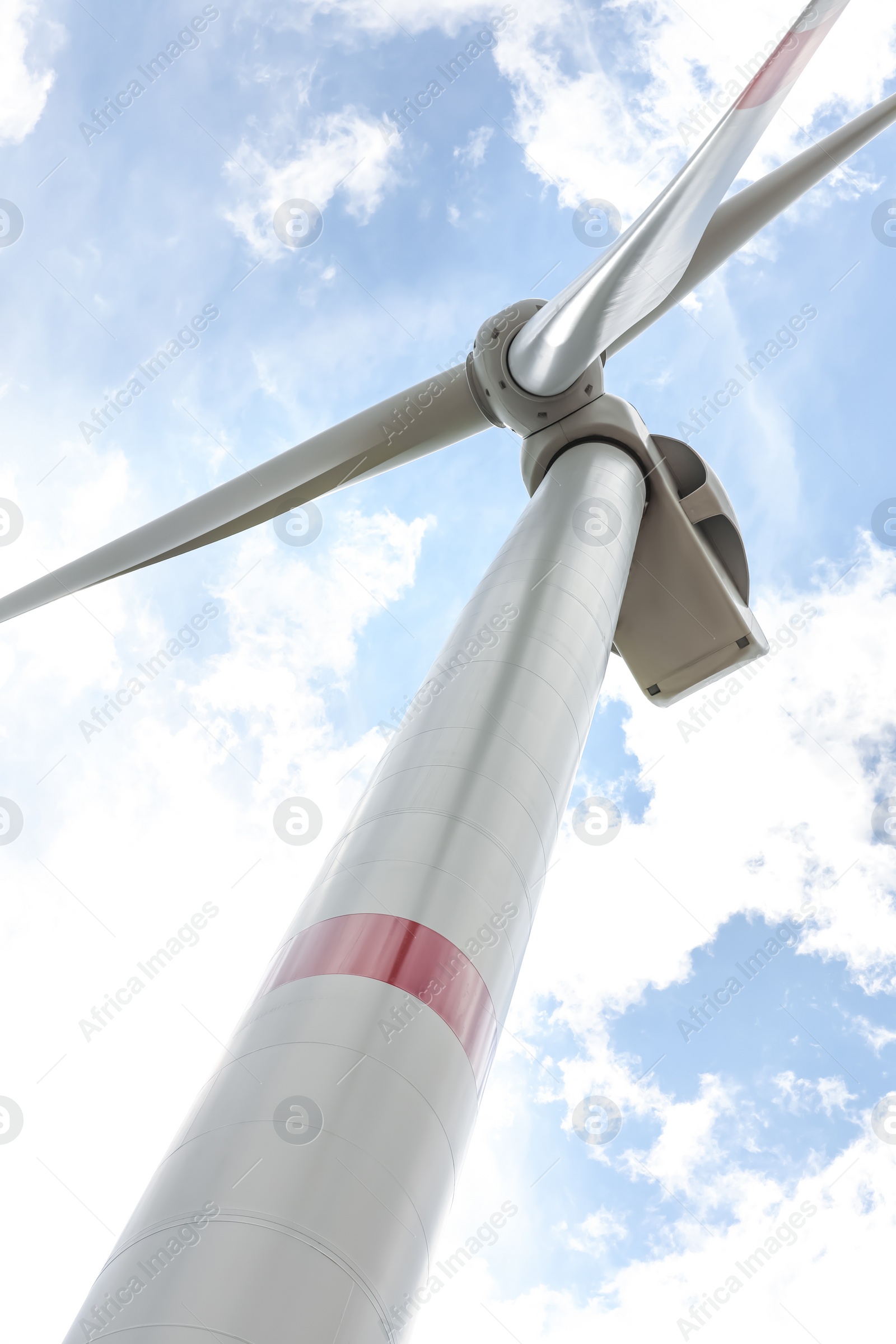 Photo of Modern wind turbine against cloudy sky, low angle view. Alternative energy source