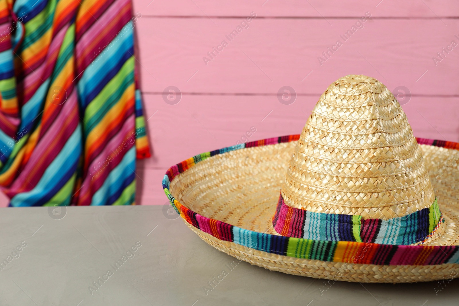 Photo of Mexican sombrero hat on grey table, closeup. Space for text