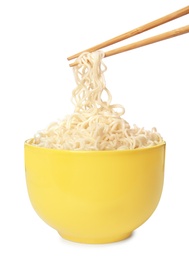 Chopsticks with tasty instant noodles over bowl isolated on white