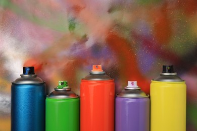 Photo of Cans of different graffiti spray paints on color background, flat lay. Space for text