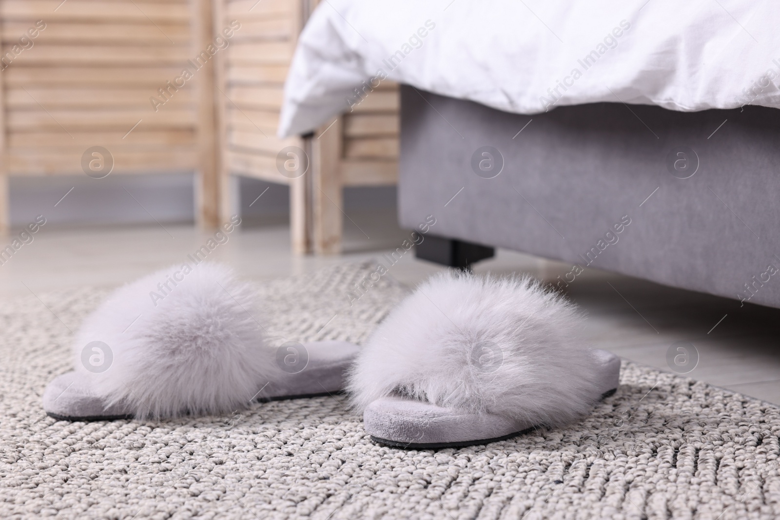 Photo of Grey soft slippers on carpet at home