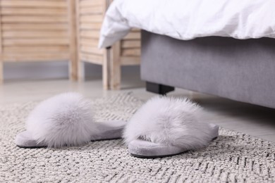 Photo of Grey soft slippers on carpet at home