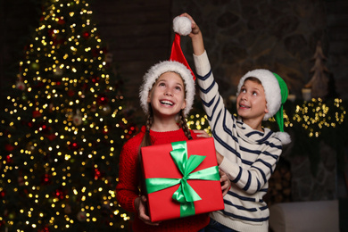 Portrait of happy children with Christmas gift at home