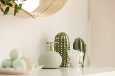 Photo of Dispenser and cotton swabs on white shelf in bathroom