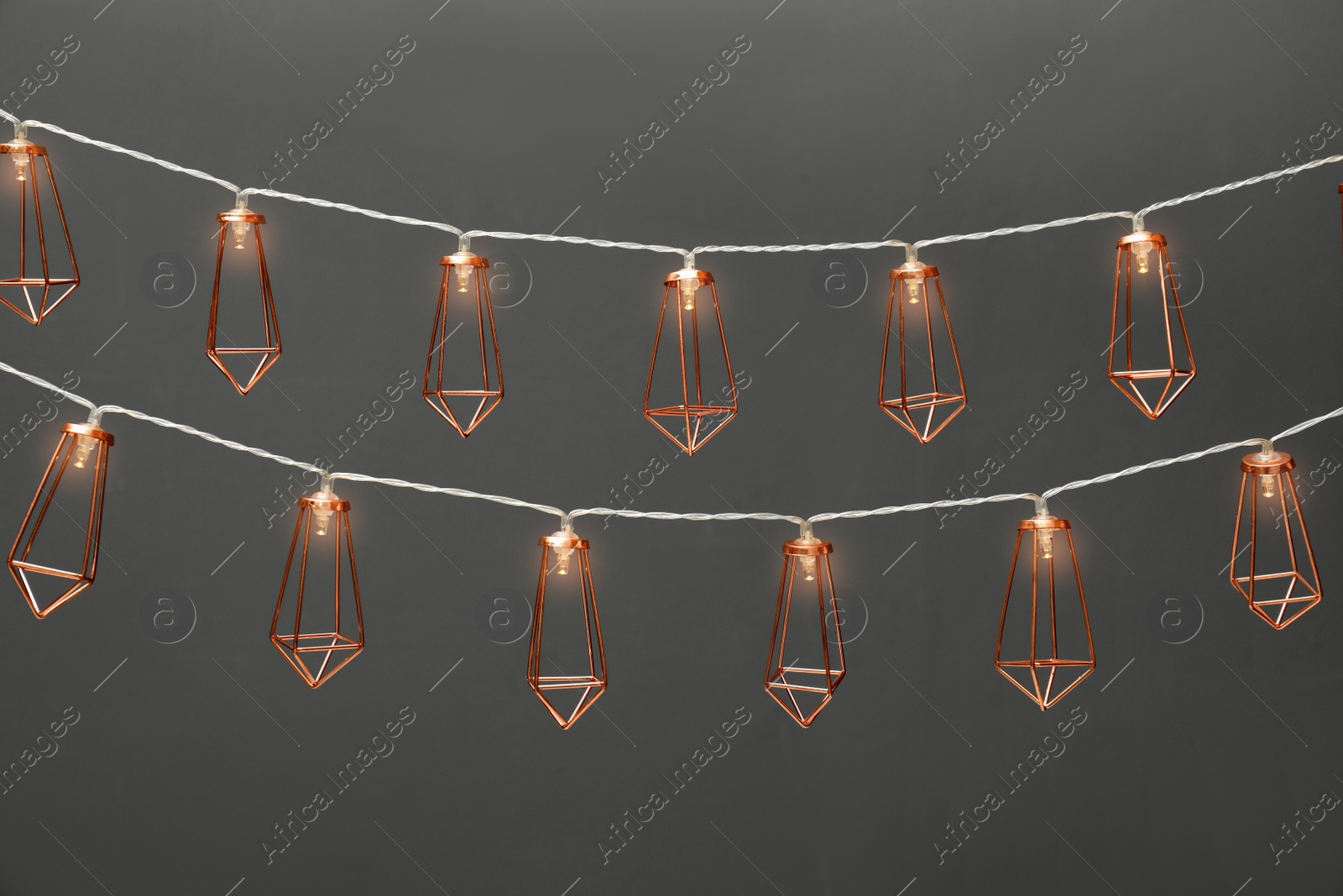 Photo of Garlands of lamps with light bulbs on grey background