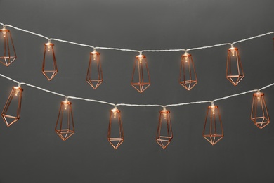 Photo of Garlands of lamps with light bulbs on grey background