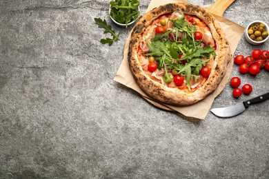 Photo of Tasty pizza with meat and arugula on grey table, flat lay. Space for text