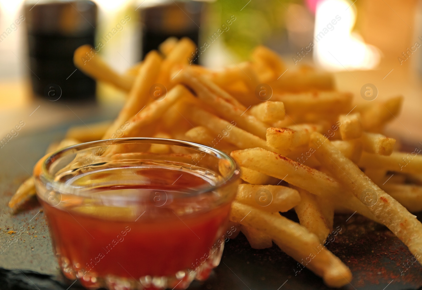 Photo of Delicious hot french fries with red sauce served on table, closeup