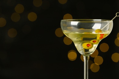 Glass of Classic Dry Martini with olives on blurred background. Space for text