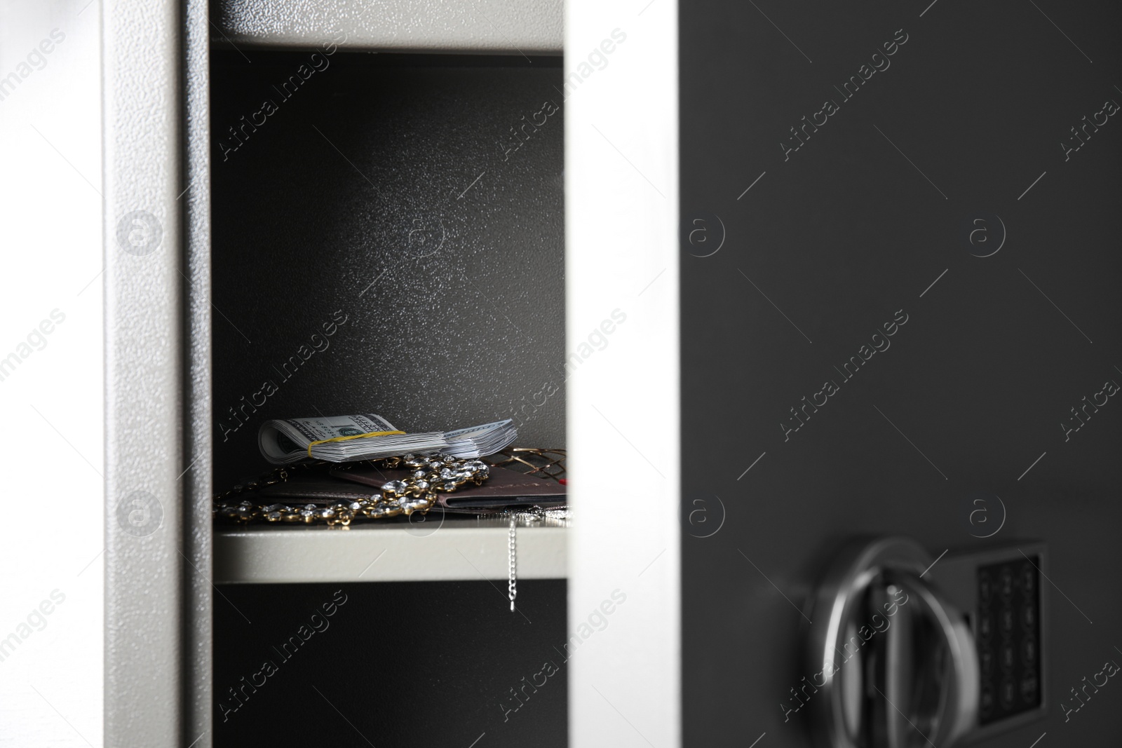 Open steel safe with money and jewelry, closeup Photo of Open steel safe with money and jewelry, closeup