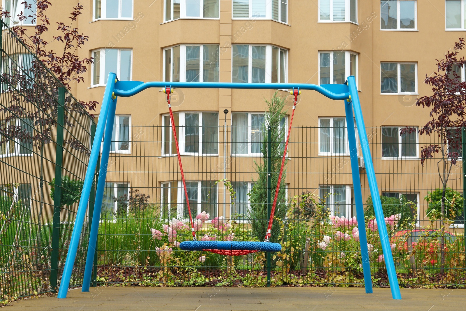 Photo of Light blue nest swing on outdoor playground in residential area