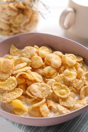 Photo of Tasty cornflakes with milk in bowl on table, closeup