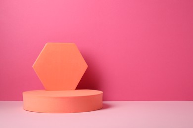 Photo of Geometric figures on table against pink background, space for text. Stylish presentation for product