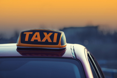 Photo of Taxi car with yellow roof sign outdoors, closeup