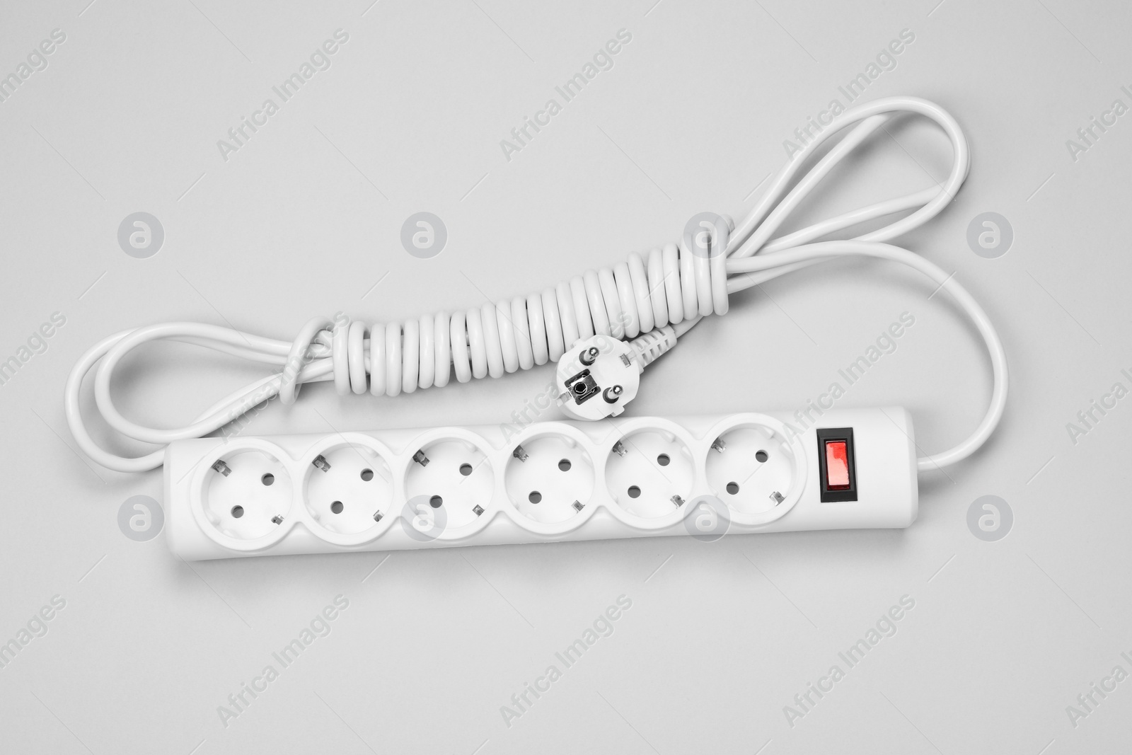 Photo of New power strip with switch button on white background, top view
