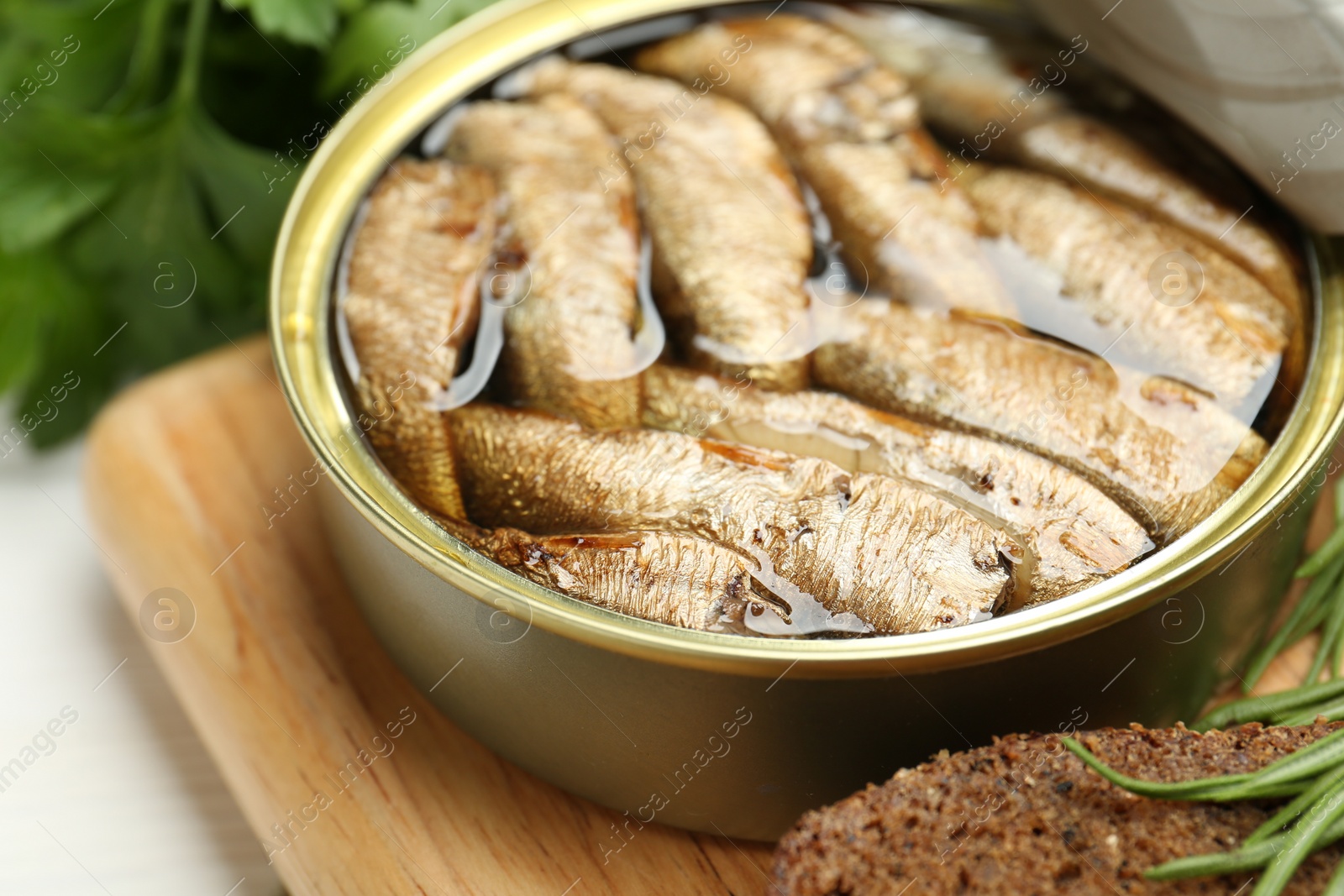 Photo of Open tin can of sprats on table, closeup