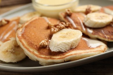 Tasty pancakes with sliced banana on plate, closeup