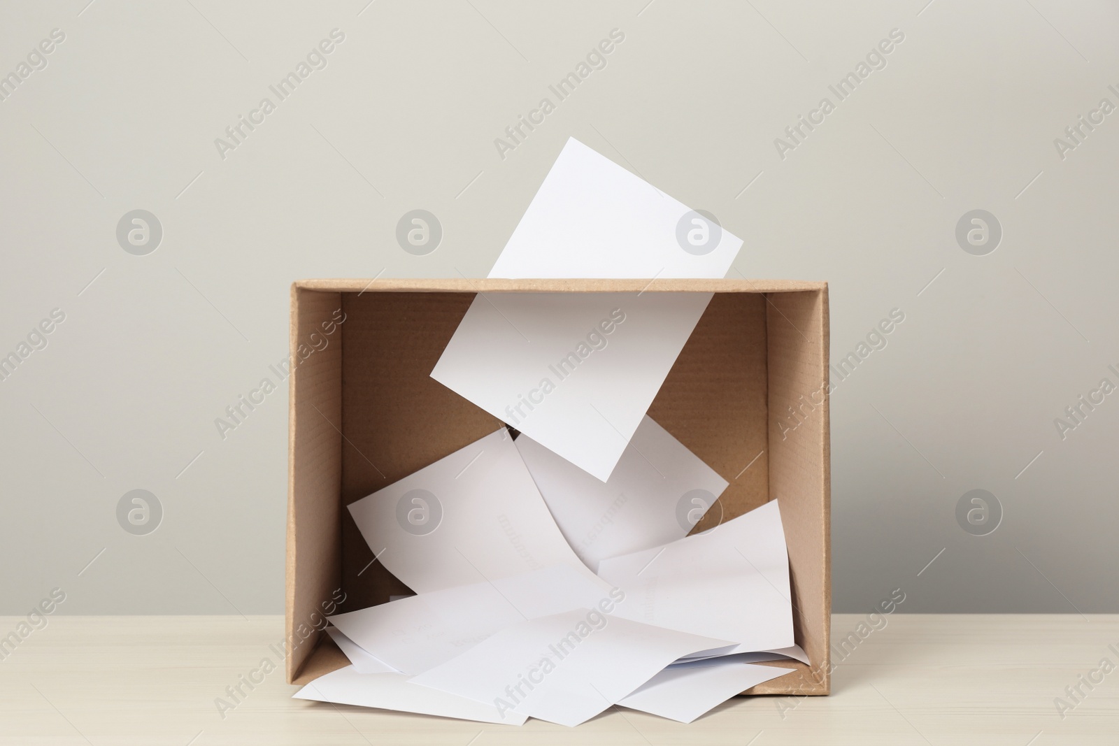 Photo of Ballots in box on table against light grey background