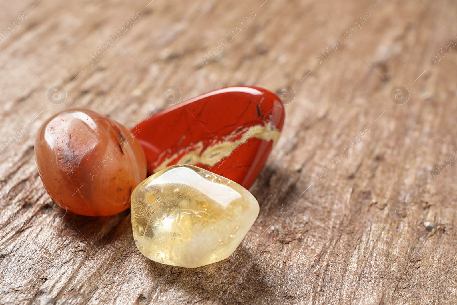 Photo of Beautiful jade, carnelian agate and citrine quartz gemstones on textured surface