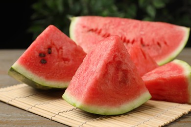 Photo of Slices of tasty ripe watermelon on wooden table, closeup