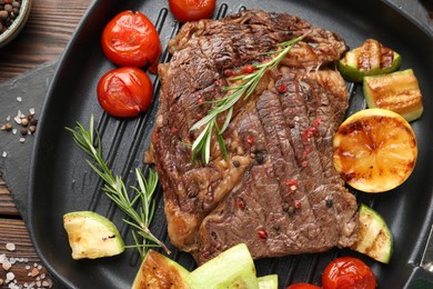 Photo of Delicious grilled beef steak and vegetables on table, top view