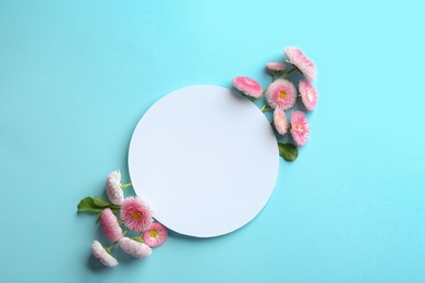 Flat lay composition with spring daisy flowers and card on color background. Space for text