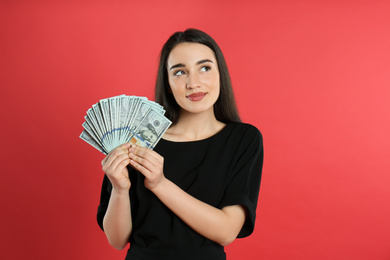 Photo of Emotional young woman with money on crimson background