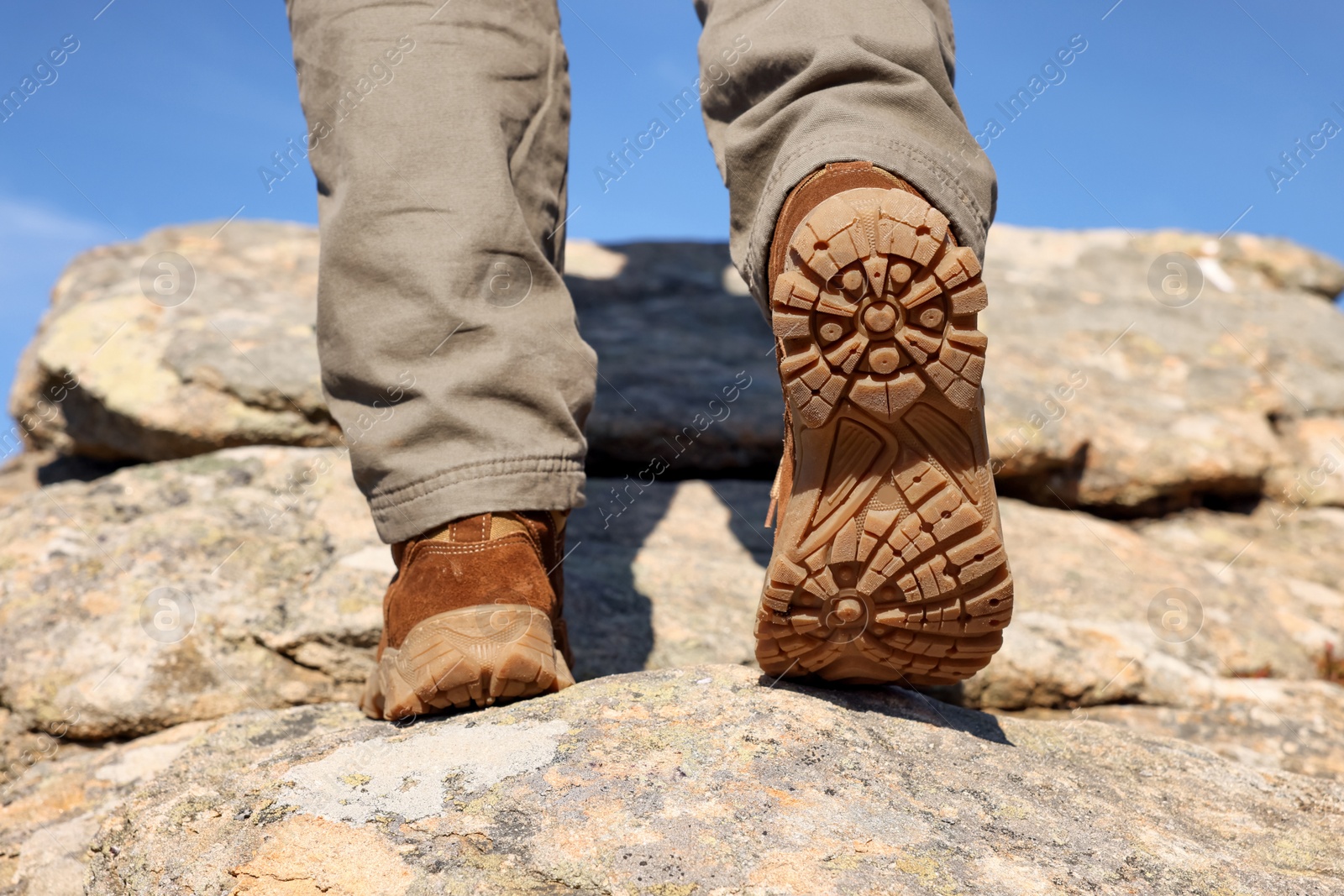 Photo of Tourist climbing on cliff, closeup of legs