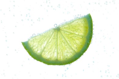 Photo of Slice of lime in sparkling water on white background. Citrus soda
