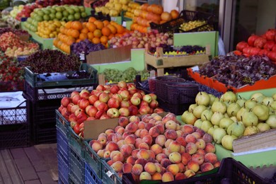 Photo of Many fruits and berries in crates selling outdoors