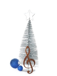 Composition with small Christmas tree, decor and wooden music note on white background