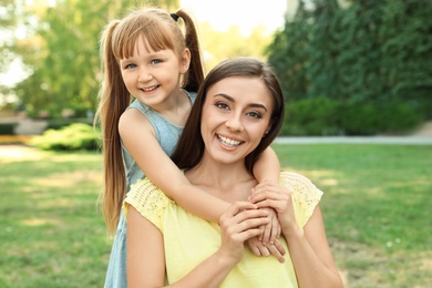 Photo of Mother with her cute child in green park on sunny day. Happy family